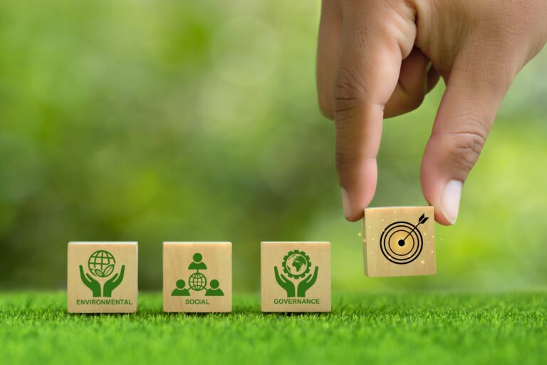 ESG concept of environmental, social and governance. Hand puts wooden cubes with target board icons with ESG icons on green background. Environmental and Business Goals Together.Sustainable Resources